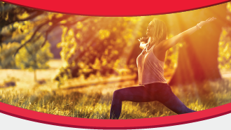 Person practicing yoga in a sunny outdoor setting with trees and grass, framed by red curves.