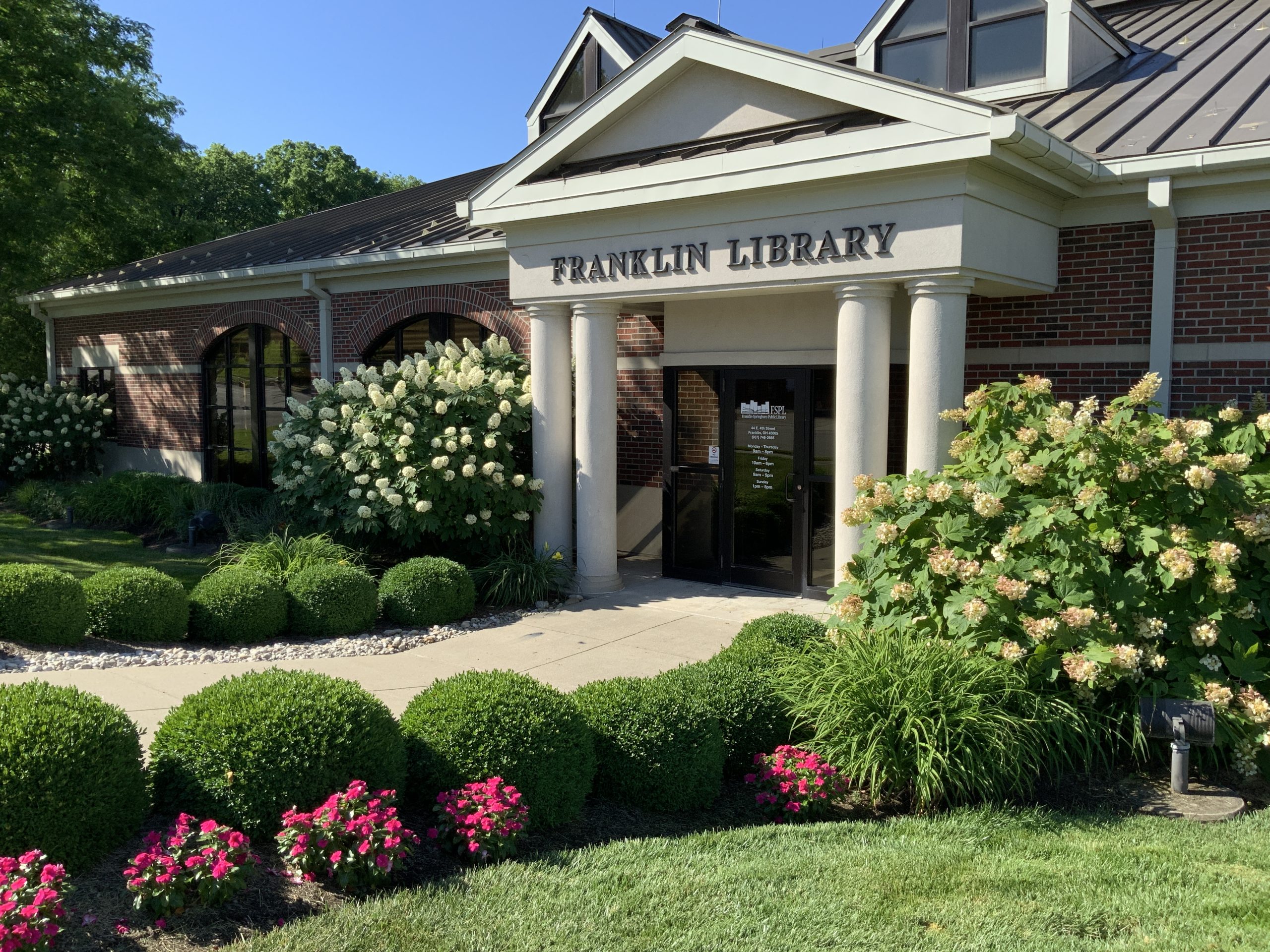 Exterior of the Franklin Library with brick walls, columns, and landscaped gardens.